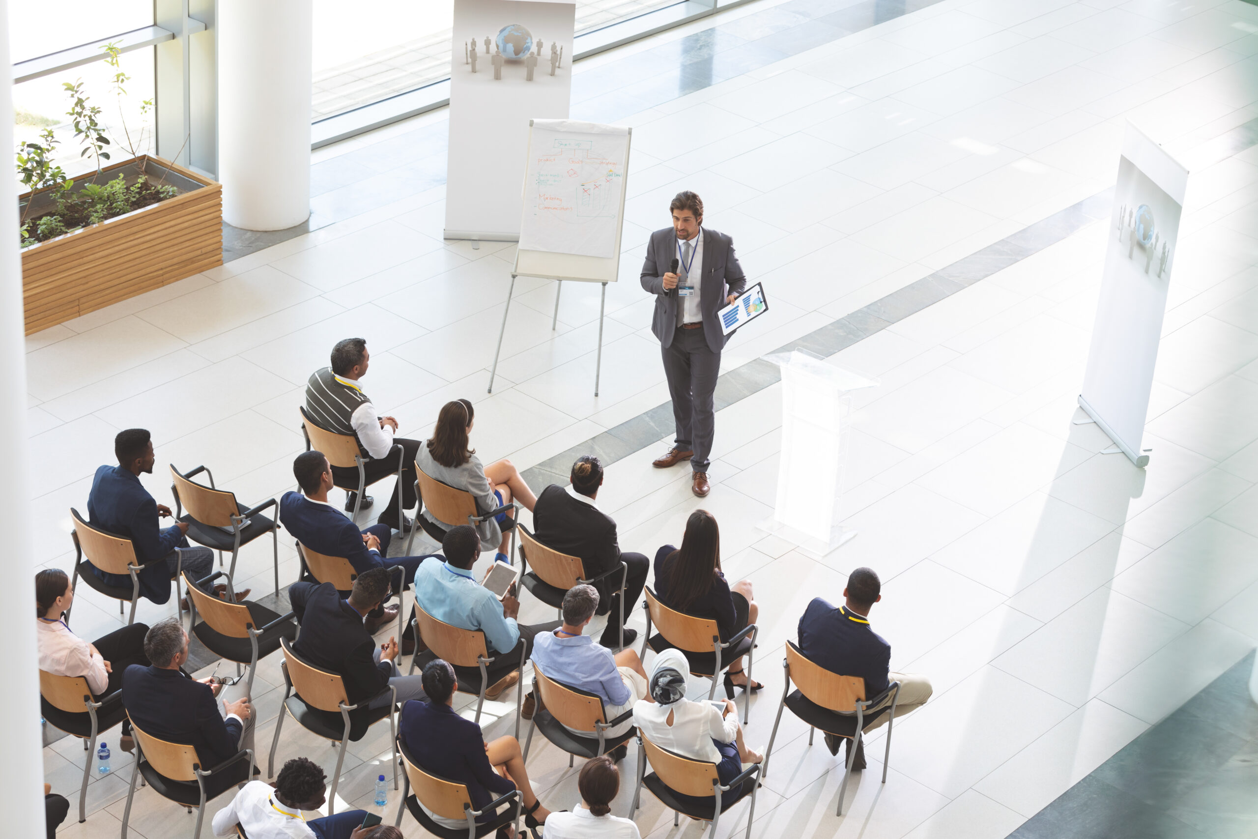 male speaker with digital tablet speaks in a business seminar