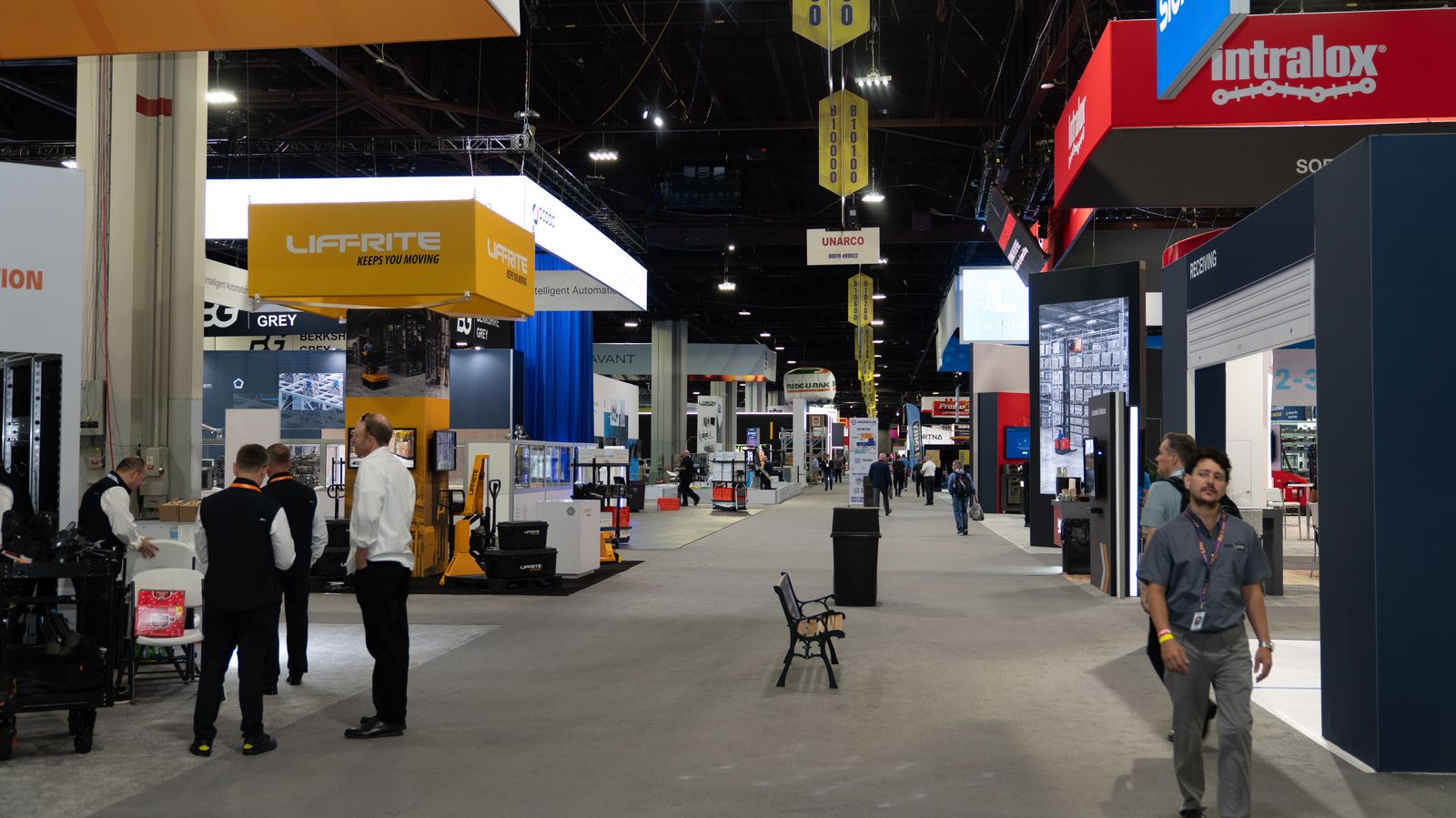 Busy trade show aisle lined with exhibitor booths