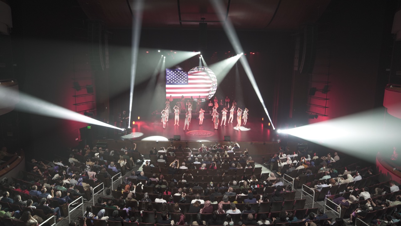 Moving-head light beams over a full audience at Byers Theatre during the IFLC Symphony of the Earth show